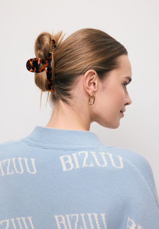Zbliżenie na włosy modelki upięte szylkretową klamrą z logo bizuu WILDA.