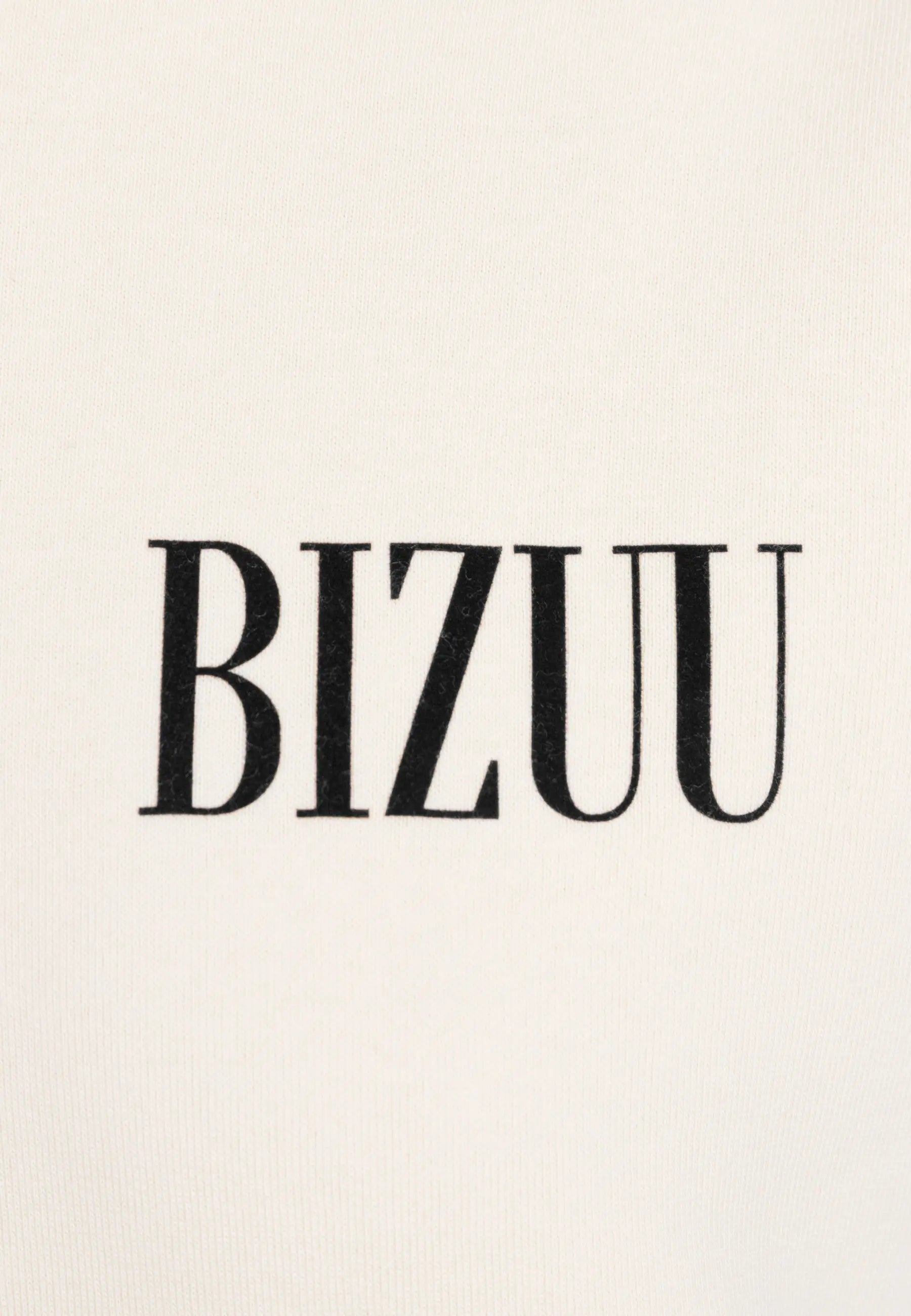 Zbliżenie na logo BIZUU na przodzie kremowej bluzy LINDI.